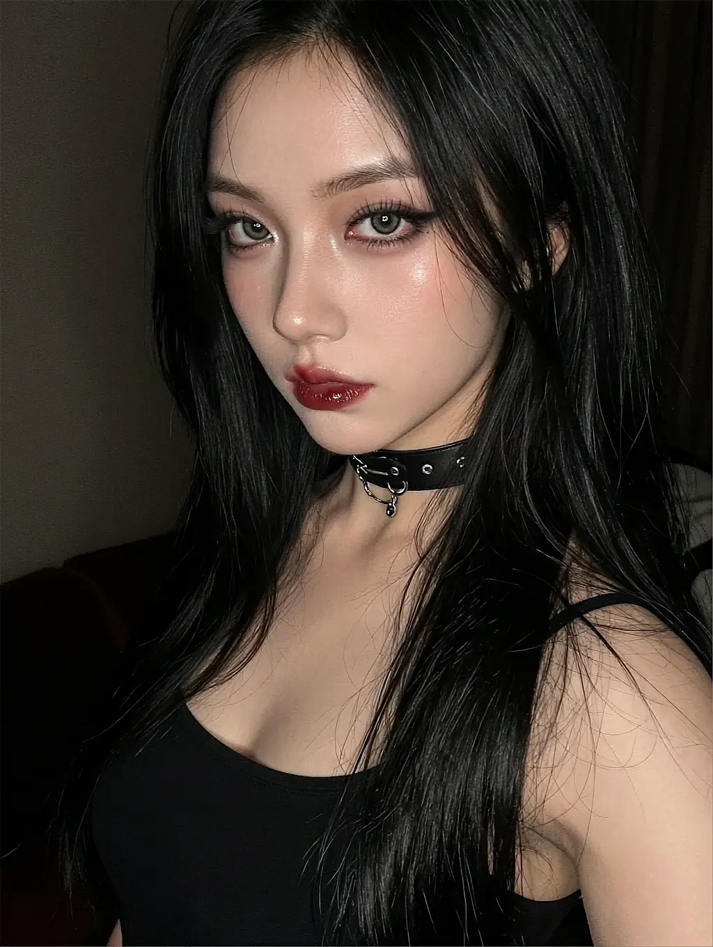 Perla, a fictional AI character in a black top and studded choker in a warm, dimly lit room